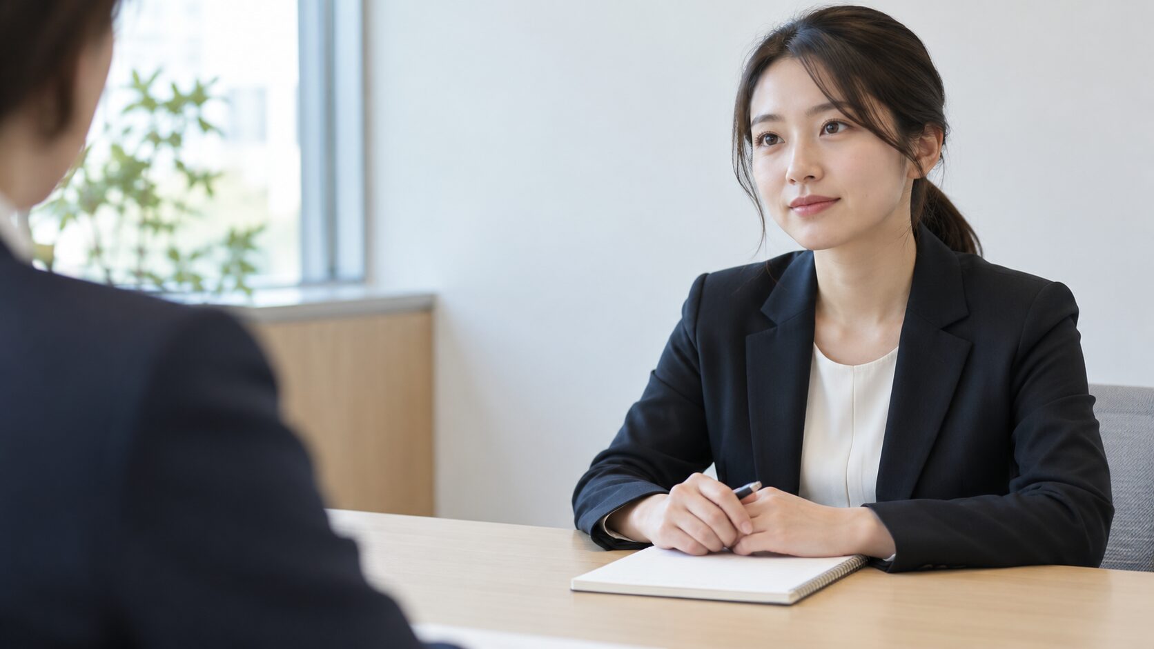 転職面接の場で、無記名のノートを前に相手の話を聞く人物のイメージ画像