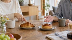 食卓で二つの軽食を前に、互いの希望を相談する二人の手元のイメージ画像